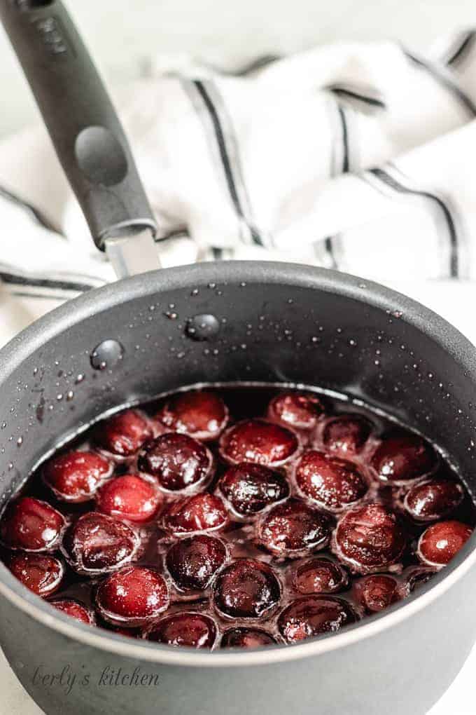 Cherries, water, sugar, a lemon juice in a saucepan.