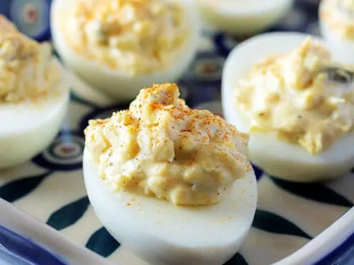 Classic deviled eggs on a blue and white platter.