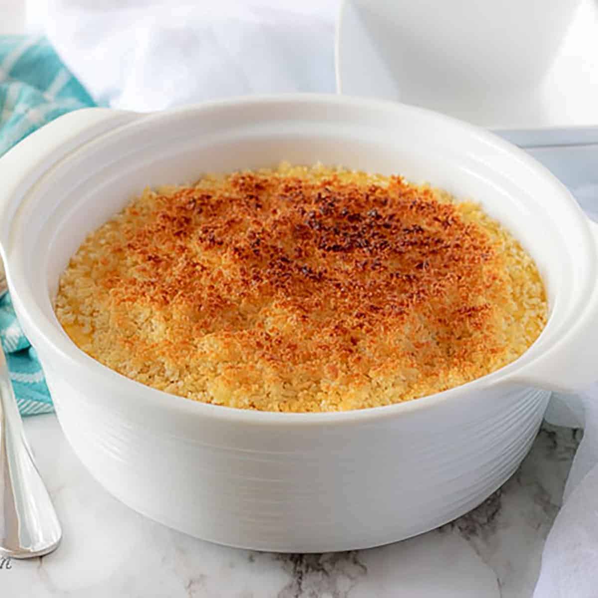 Casserole dish filled with funeral potatoes topped with toasted breadcrumbs.