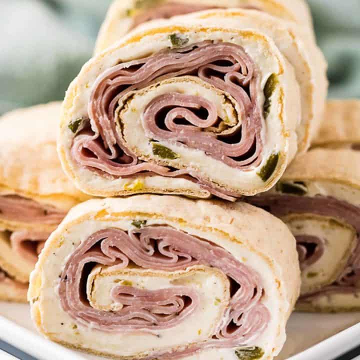 Ham and cheese pinwheels stacked on a plate.