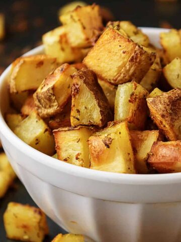White bowl with oven baked home fries.