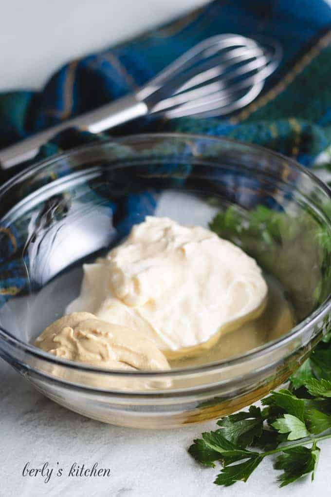 Mayonnaise, vinegar, and other ingredients in a mixing bowl.