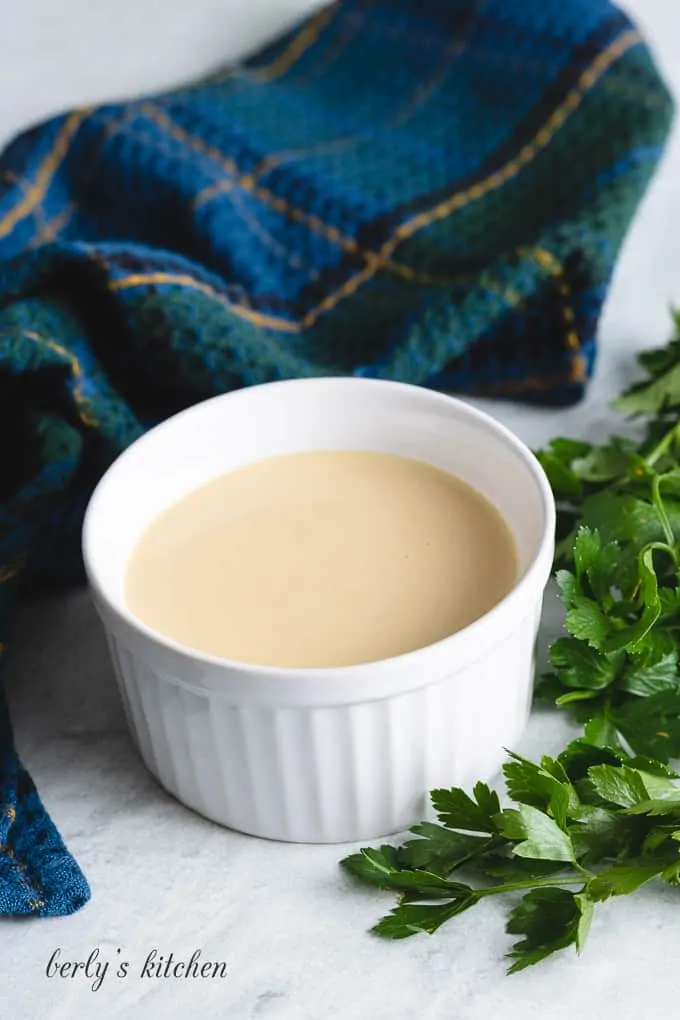 The salad dressing served in a small white ramekin.