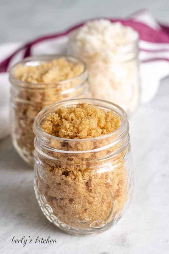 Light, dark, and maple syrup sugars in mason jars.