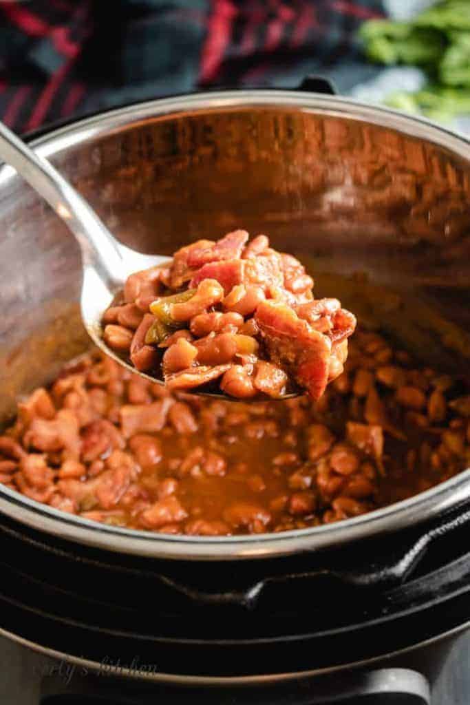 The baked beans being scooped from the cooker.