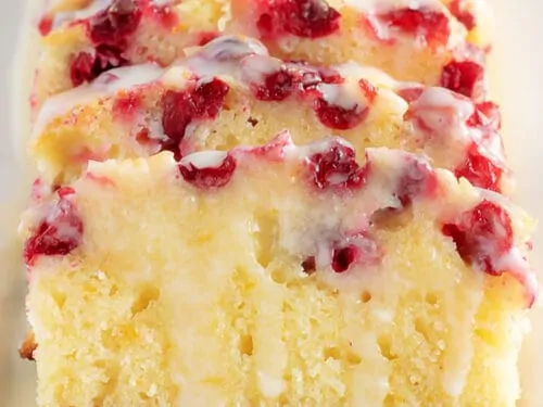 Sliced orange cranberry bread with glaze.