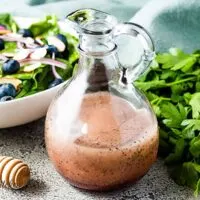 Poppy seed dressing next to a blueberry salad.