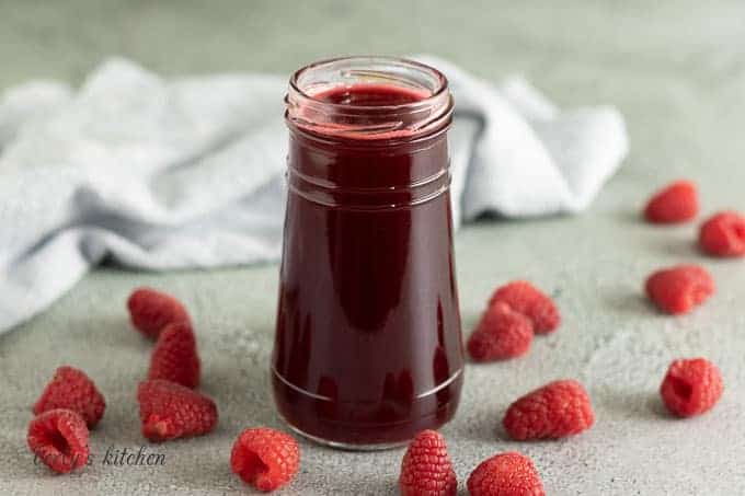 A jam jar filled with the raspberry simple syrup.