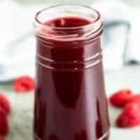 A small jar filled with the raspberry simple syrup.