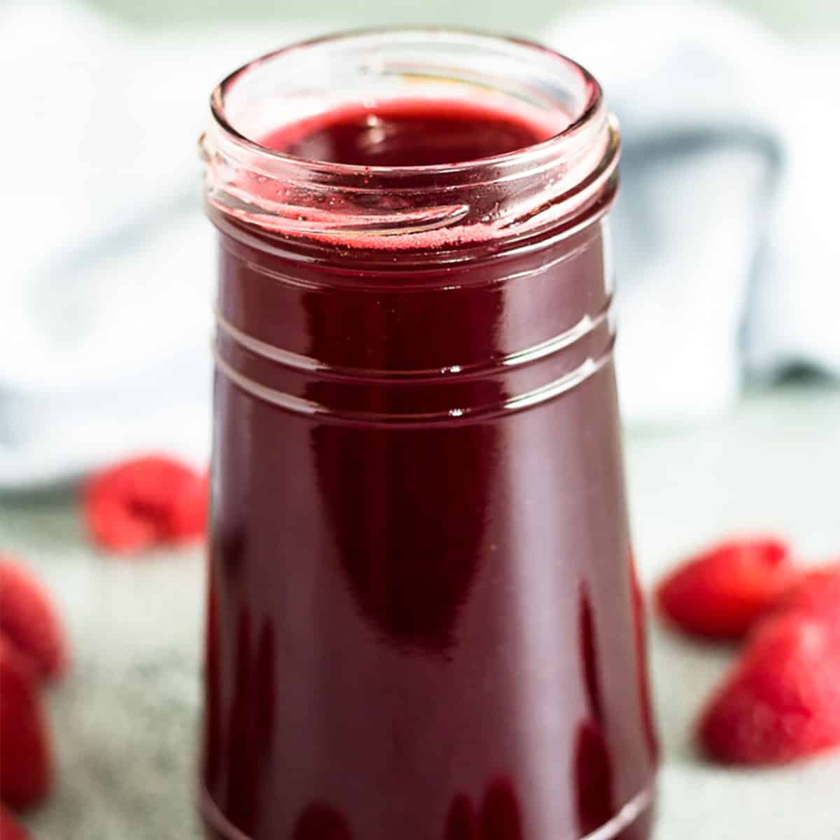 A small jar filled with the raspberry simple syrup.