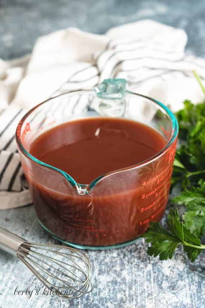 BBQ sauce and beef broth in a large measuring cup.