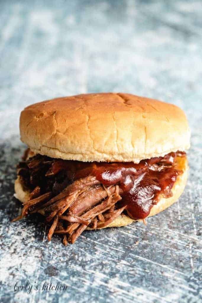 A bbq beef sandwich served with bbq sauce.