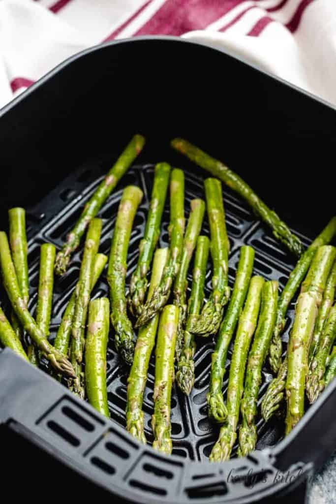 The raw asparagus placed in the basket to cook.