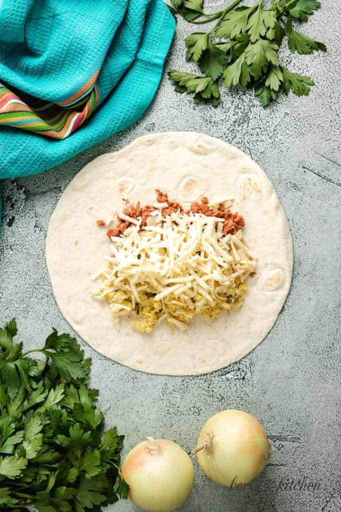 Portions of each ingredient added to a flour tortilla.