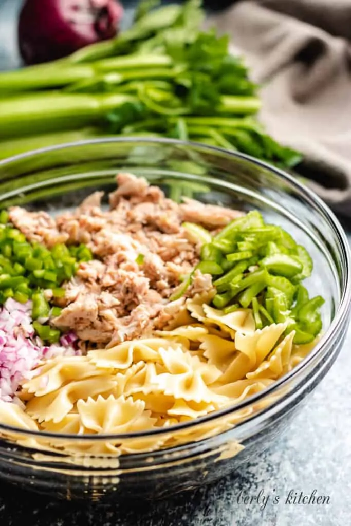 Bow ties, seafood, and other ingredients in a bowl.