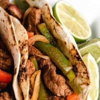 Up-close view of a fajita served with a halved lime.