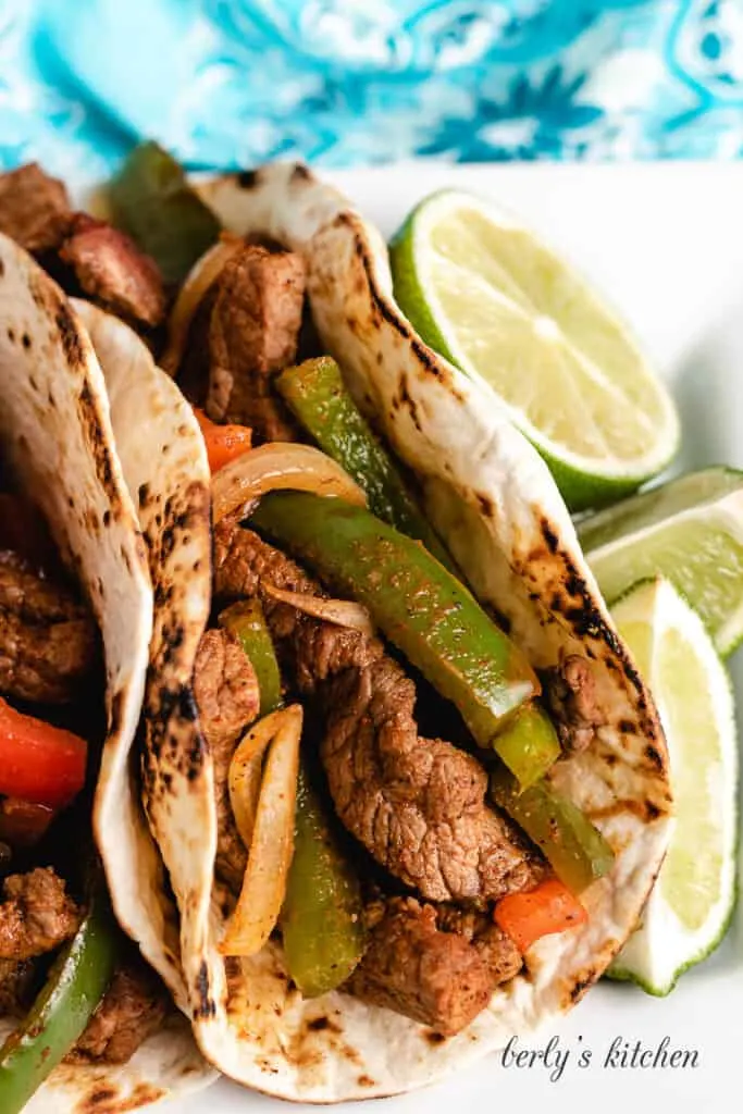 Up-close view of a fajita served with a lime wedge.