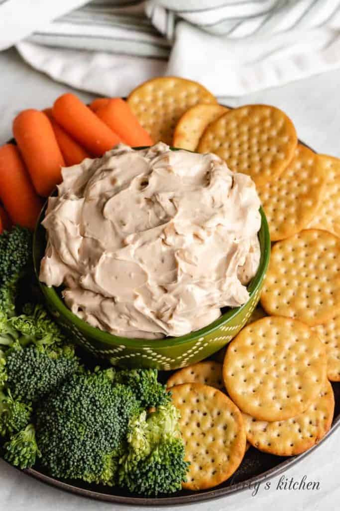 Top-down view of the dip with fresh veggies and crackers.