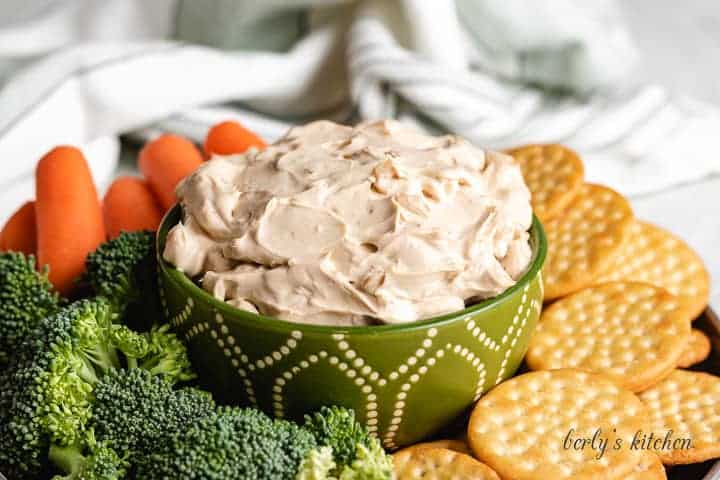 French onion cream cheese dip surrounded by veggies and crackers.