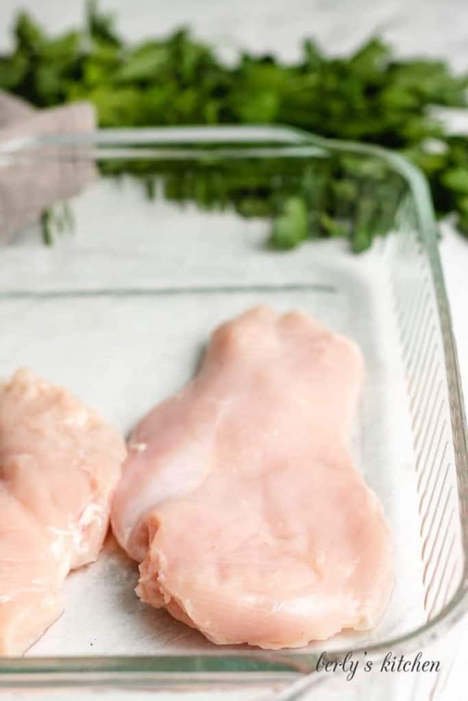 Raw chicken in a large baking dish.