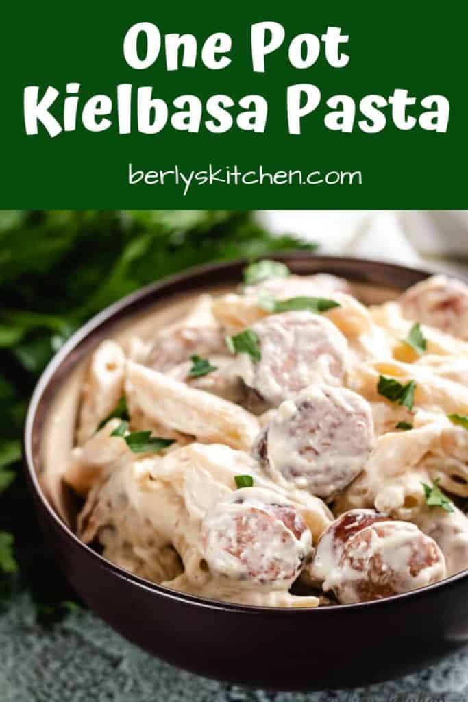 Kielbasa pasta served in a bowl topped with parsley.