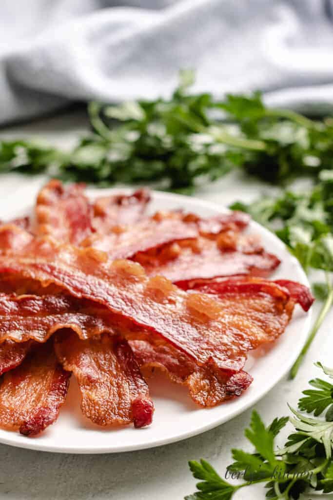 Strips of cooked bacon on a plate.