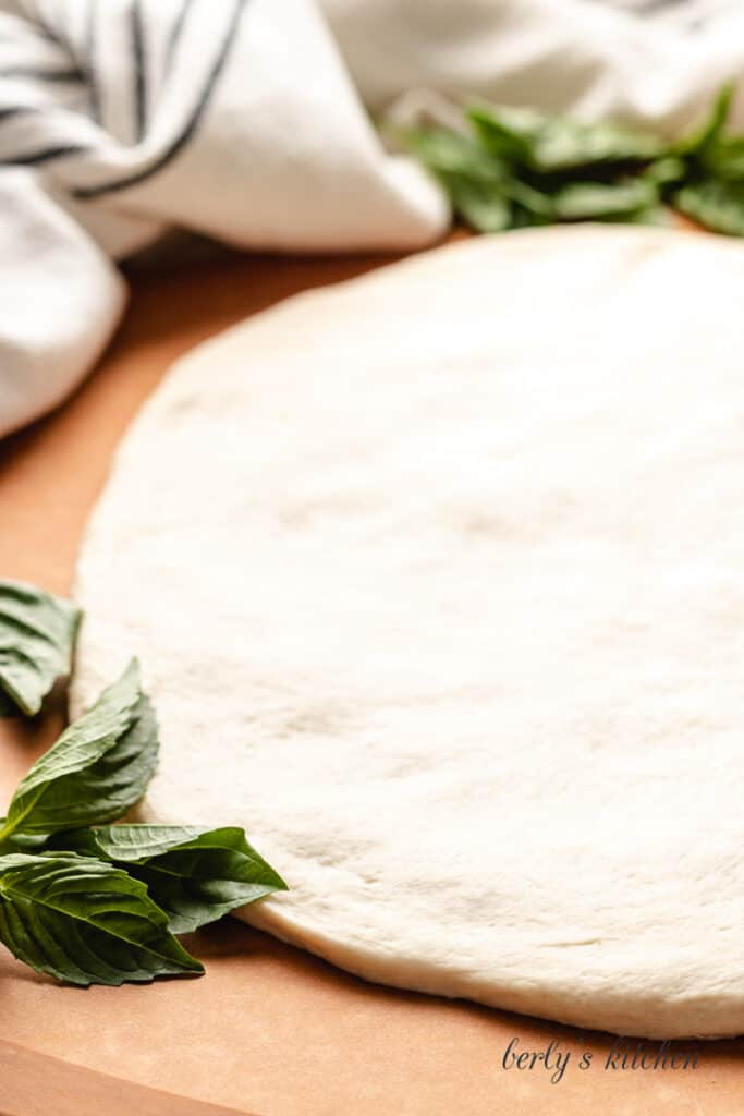 Raw pizza dough on a counter-top.