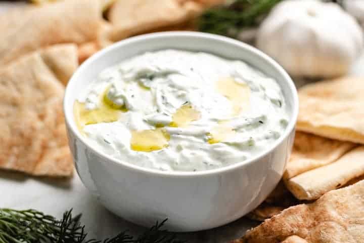 The tzatziki sauce in a bowl topped with olive oil.