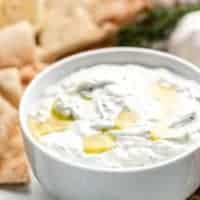 The tzatziki sauce served in a small bowl with chips.