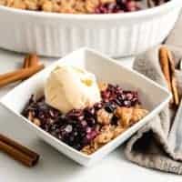 A scoop of ice cream on the blueberry crisp.