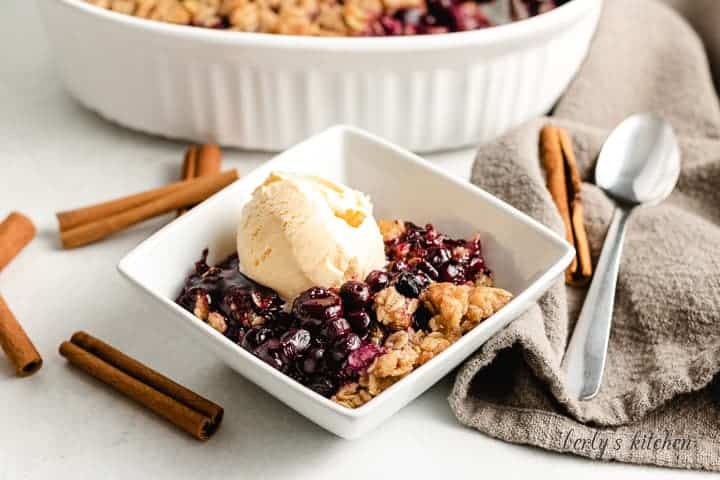 A scoop of ice cream on the blueberry crisp.