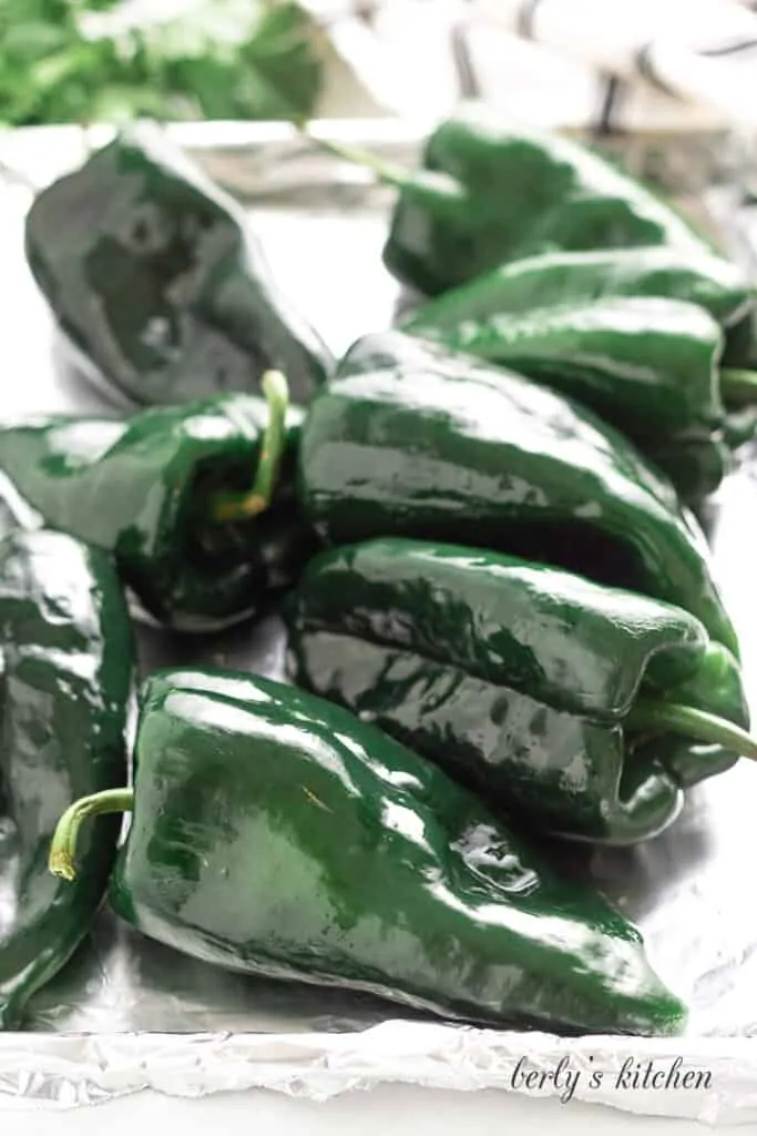 Fresh pablano peppers on a lined sheet pan.