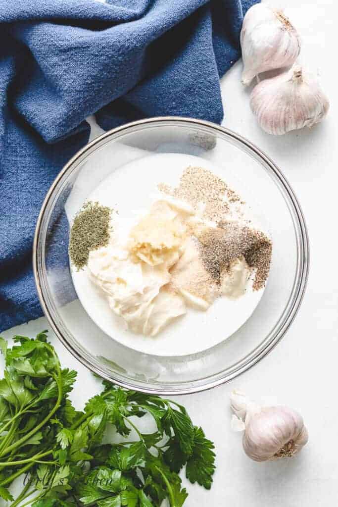 Mayonnaise, garlic, and other ingredients in a mixing bowl.