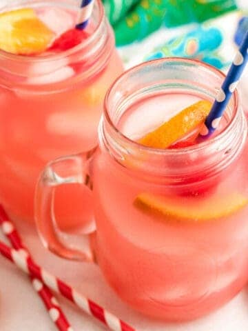 Two mugs of the tropical vodka punch with fruit.