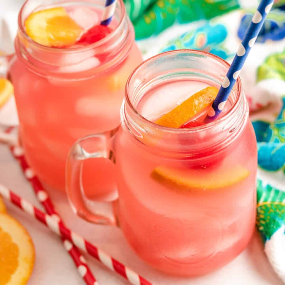 Two mugs of the tropical vodka punch with fruit.