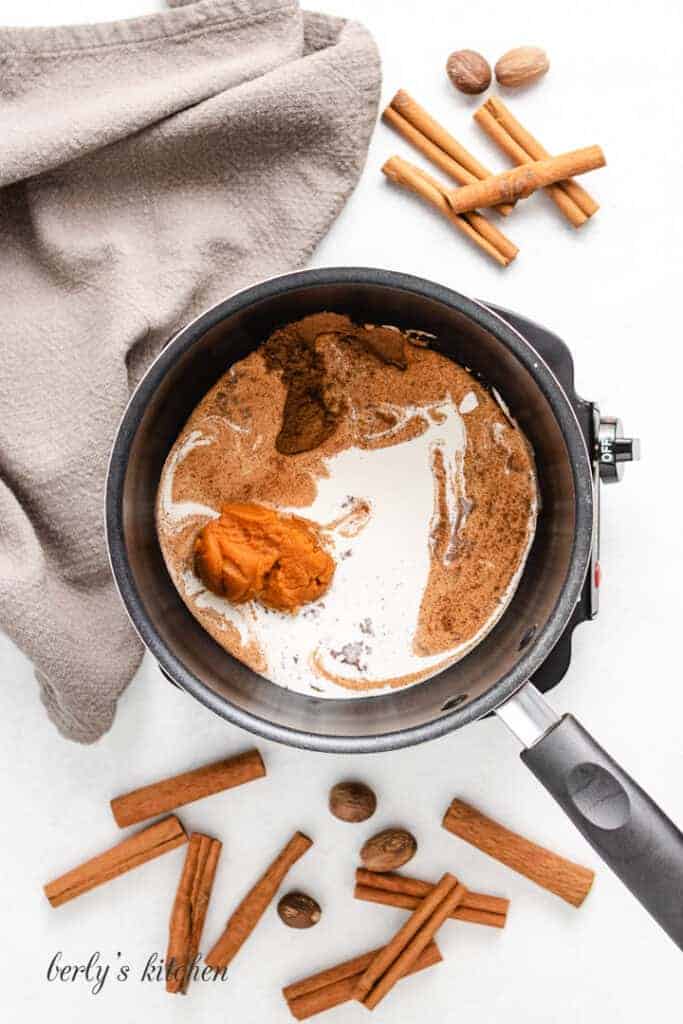 Spices and heavy cream in a saucepan.