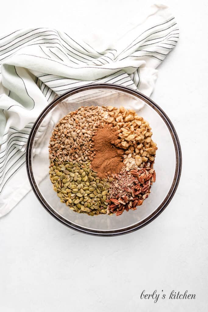 Pumpkin Spice Granola Oats, spices, and other ingredients in a mixing bowl.