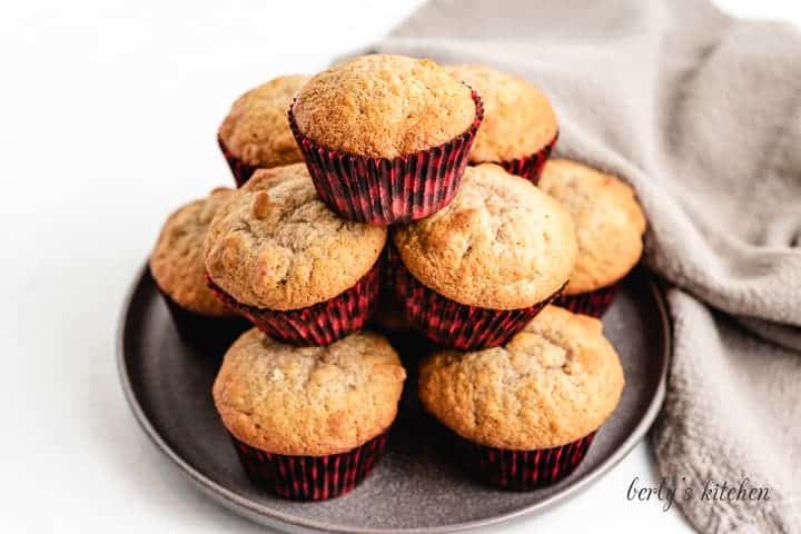 Banana bread muffins stacked on a plate.