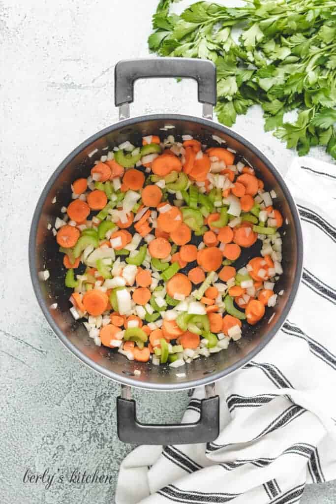 Carrots, celery, and other ingredients in a stock pot.