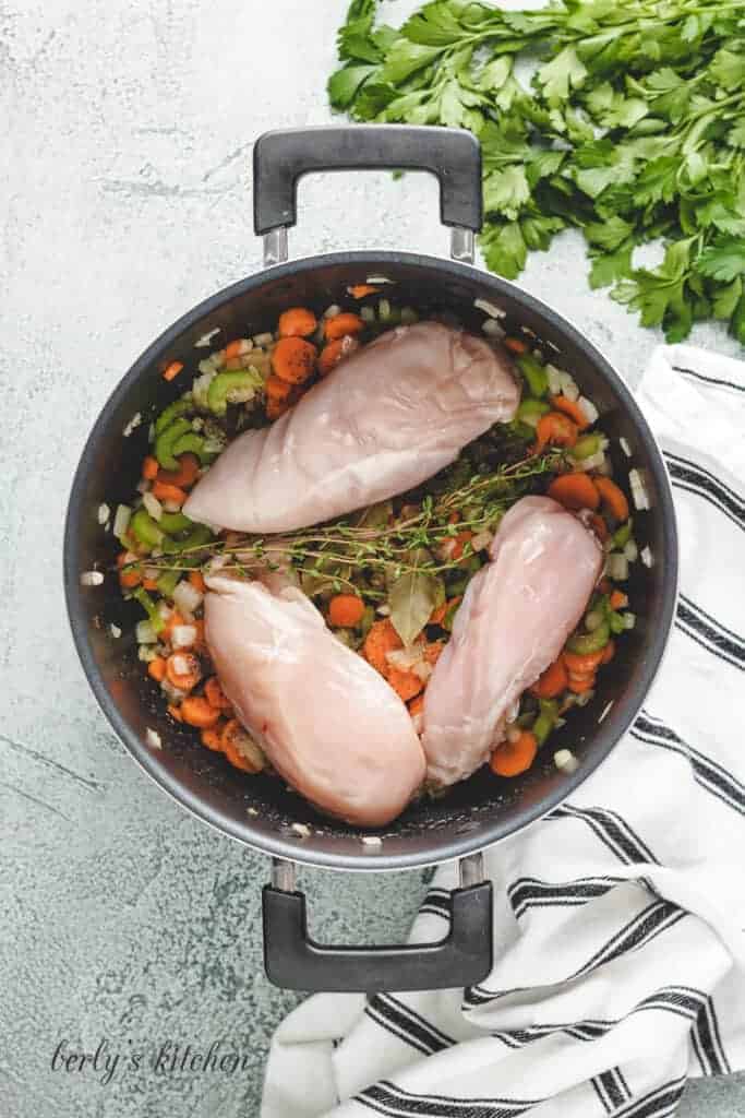 Chicken breasts added to the stock pot.