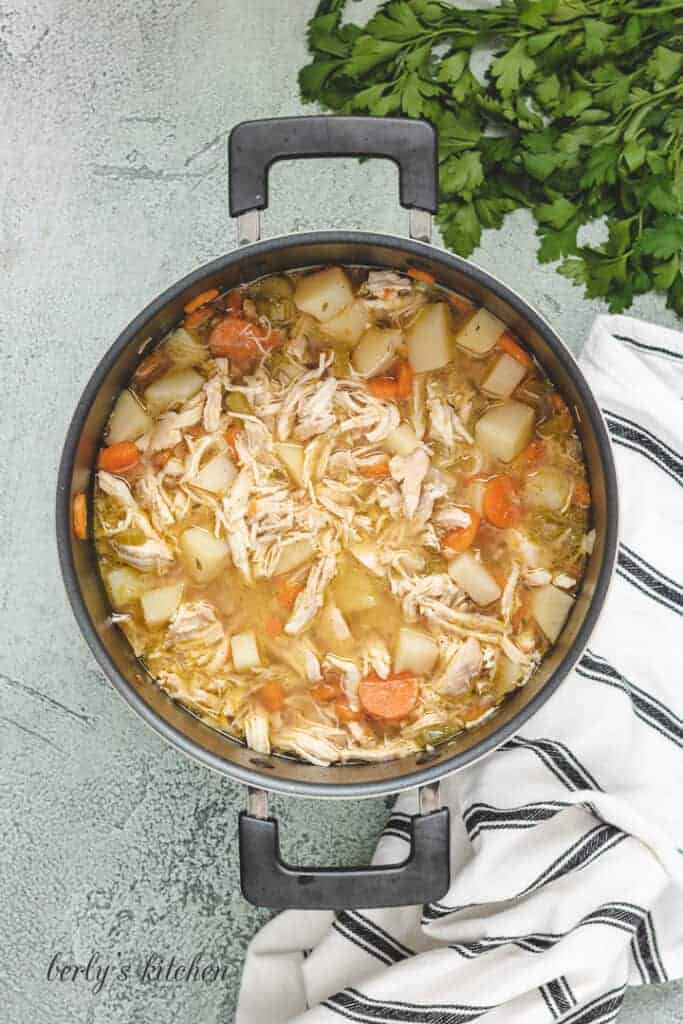 The meat has been shredded and returned to the pot.