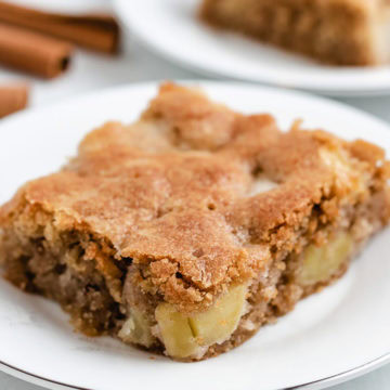 A slice of fresh apple cake on a plate.