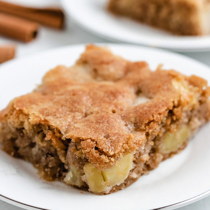 A slice of fresh apple cake on a plate.