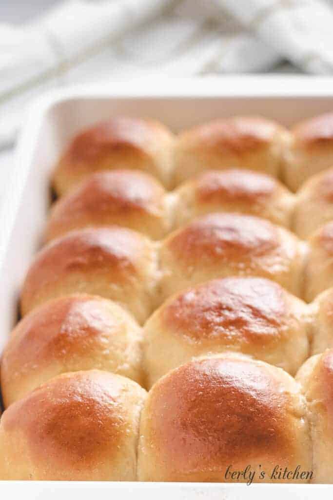 Baked hawaiian rolls sitting in a baking dish.