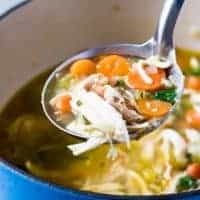 A ladle of soup held up to show the ingredients.