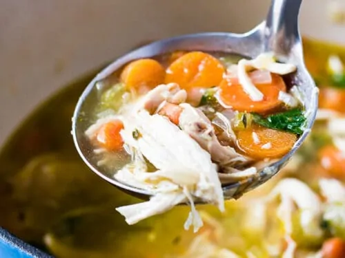 A ladle of soup held up to show the ingredients.