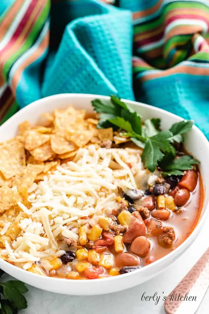 A serving of stovetop taco soup topped with fresh garnishments.