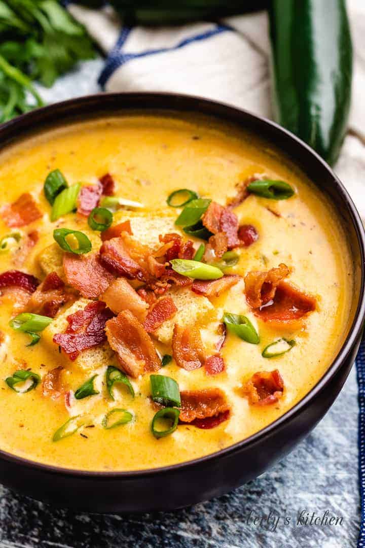 Cheesy beer soup topped with onions and bacon.