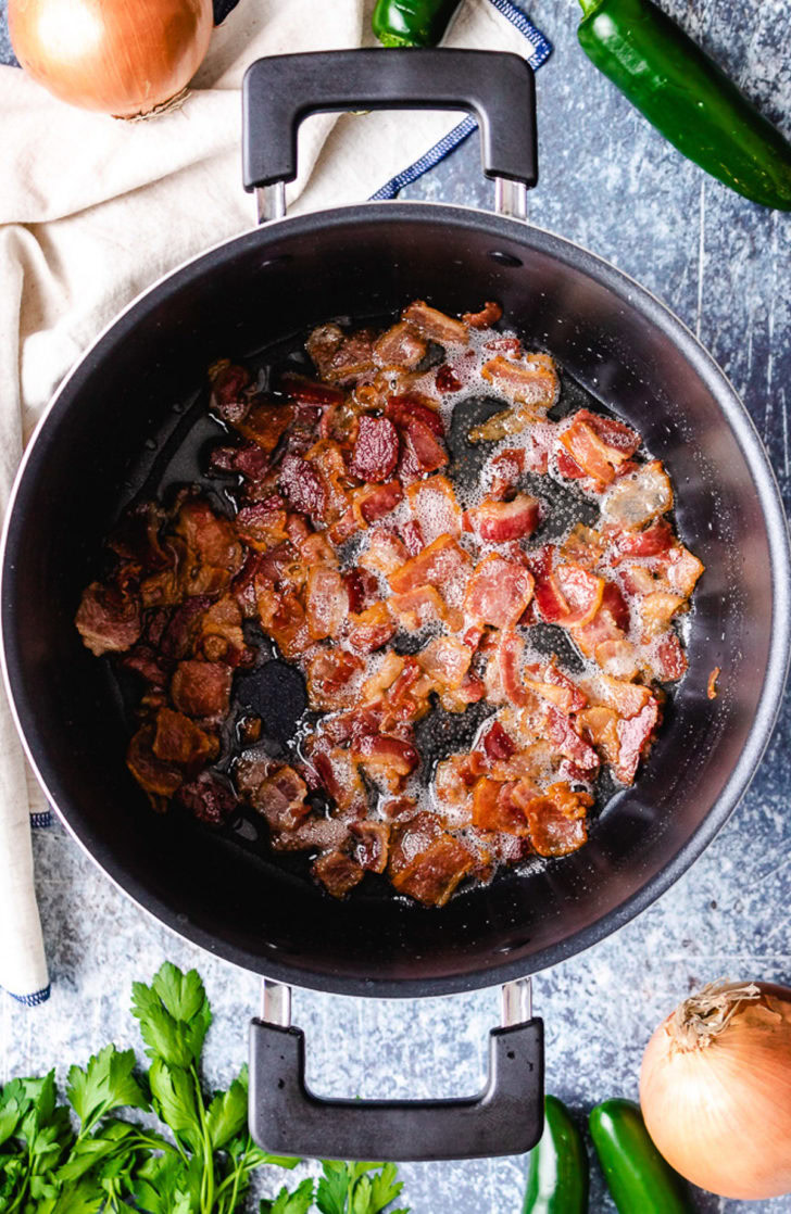 Creamy JalapeÑO Beer Cheese Soup Smoky bacon cooking in a stock pot.