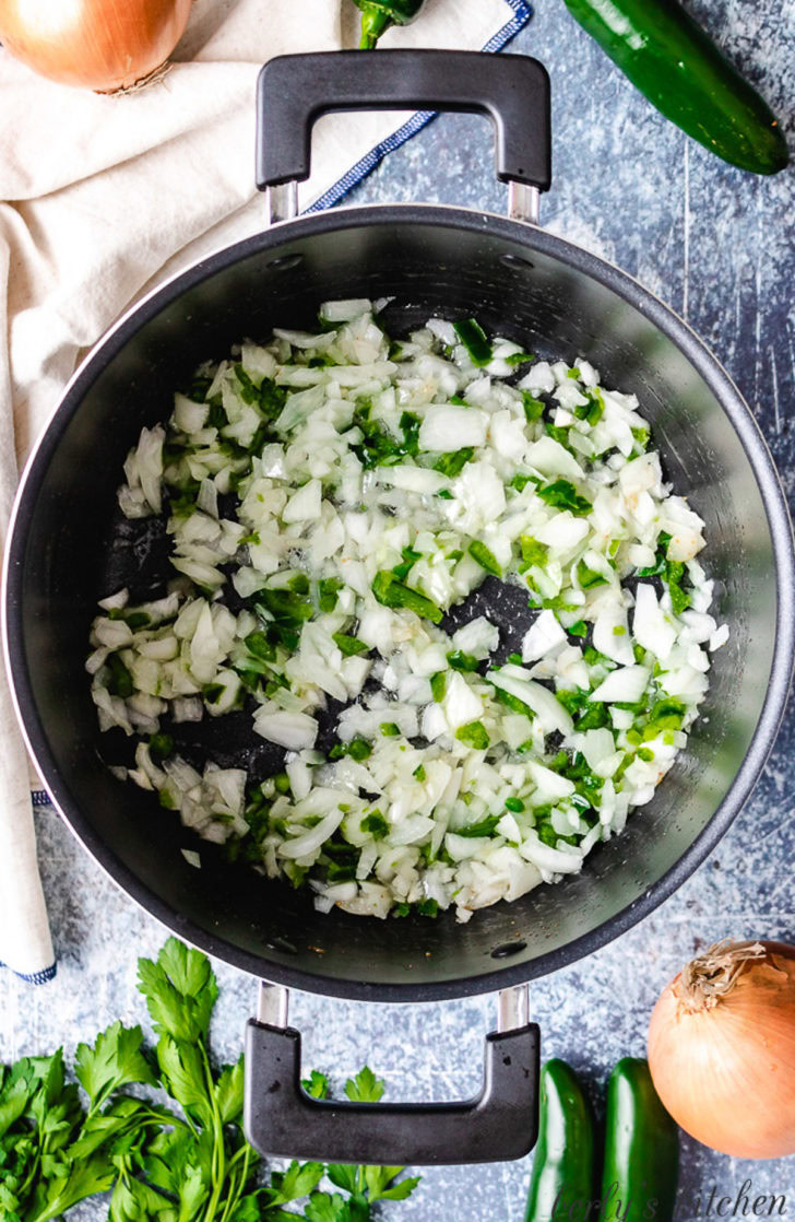 Creamy JalapeÑO Beer Cheese Soup Diced onion and jalapeno cooking in a stock pot.